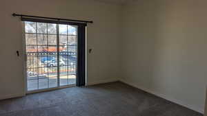 Carpeted spare room featuring crown molding and baseboards