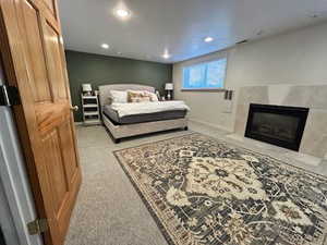 Bedroom with a tiled fireplace and recessed lighting