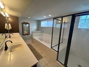 Full bathroom with a garden tub, double vanity, a shower stall, and a sink