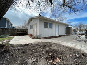 Exterior space with a patio area, fence, and board and batten siding