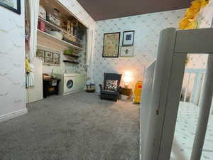 Unfurnished room with baseboards, carpet floors, washing machine and dryer, and wallpapered walls