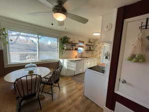 Kitchen with light wood finished floors, ceiling fan, dishwasher, white cabinets, and open shelves