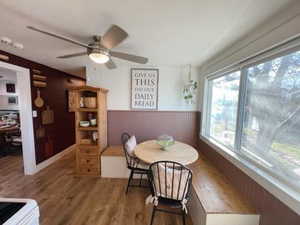 Dining room with wainscoting, ceiling fan, and wood finished floors