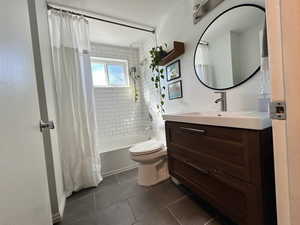 Bathroom with toilet, shower / bath combo, vanity, and tile patterned flooring