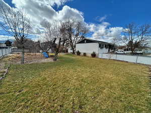 View of yard with a playground and fence