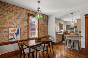 Exquisite dining area with exposed brick, big windows for loads of natural lights, and hardwood flooring.