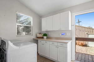 Large laundry room with newer washer and dryer, folding cabinet, and lots of cupboards and storage space. Lots of windows and natural light as well.