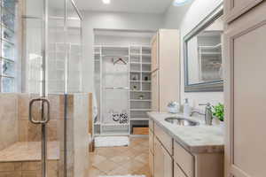 Large main-floor bathroom features a shower with a bench and multiple shower heads as well as built-in shelving and closet space.