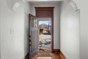 Entryway with arched walkways, original wood moulding, and cute front door.