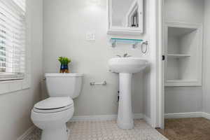 Upstairs light-filled bathroom with beautiful windows and white-tiled bathtub.