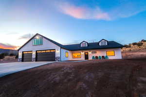 Modern farmhouse style home with stone siding and driveway