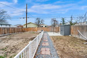 View of yard featuring a fenced backyard and a storage shed (included)