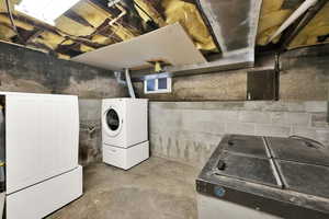 Unfinished below grade area featuring washing machine and clothes dryer