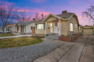 Bungalow with fence, concrete driveway, a chimney, an outbuilding, and a gate