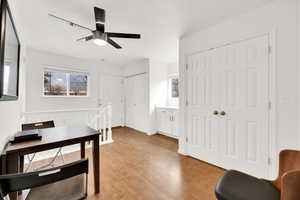 Office space featuring a healthy amount of sunlight, light wood-type flooring, and a ceiling fan