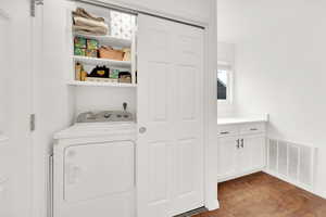 Laundry area with dark wood-style floors, visible vents, washer / clothes dryer, and laundry area