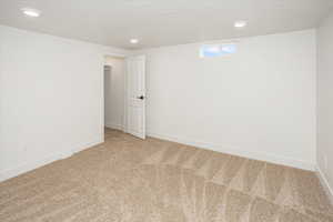 Spare room featuring recessed lighting, baseboards, a textured ceiling, and carpet flooring