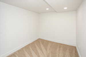 Unfurnished room with recessed lighting, light colored carpet, baseboards, and a textured ceiling