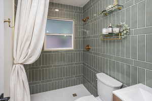 Full bathroom with vanity, toilet, and tiled shower