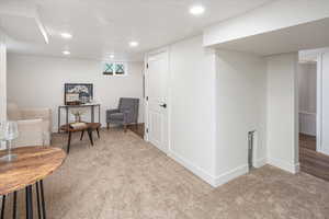 Living area with recessed lighting, baseboards, and carpet floors