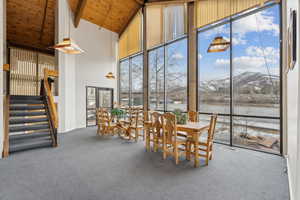 Unfurnished sunroom featuring a mountain view, wooden ceiling, and vaulted ceiling