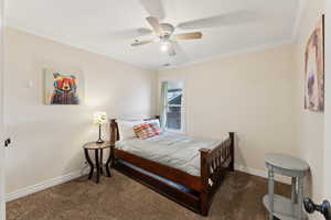 Carpeted bedroom featuring crown molding, a ceiling fan, and baseboards