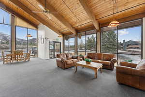 Sunroom with a ceiling fan, plenty of natural light, and wood ceiling