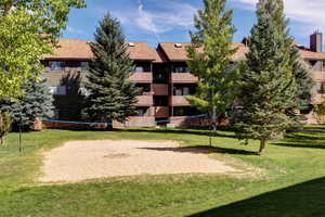 View of community with volleyball court and a yard