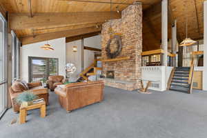 Carpeted living room with beamed ceiling, wood ceiling, visible vents, and high vaulted ceiling