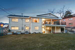 Back of house with brick siding, cooling unit, a yard, and fence