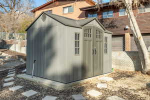 View of shed featuring fence