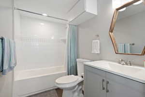 Full bathroom featuring vanity, toilet, shower / tub combo with curtain, and wood finished floors