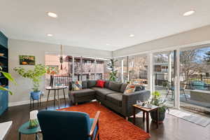 Living room with recessed lighting, baseboards, a textured ceiling, and wood finished floors