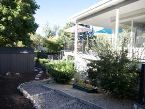 View of yard featuring an outdoor structure, a garden, fence, and a shed in the fall