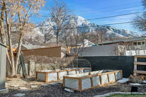 View of yard featuring a mountain view, fence, and a garden