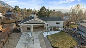 View of front of home with fence, driveway, a mountain view, a patio, and a gate