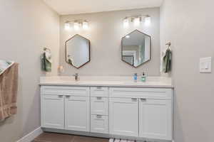 Full bath with a sink, baseboards, and double vanity