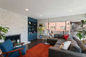 Living room with wood finished floors, recessed lighting, a fireplace, and a textured ceiling