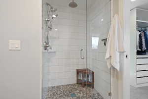 Full bath with a shower stall and a spacious closet