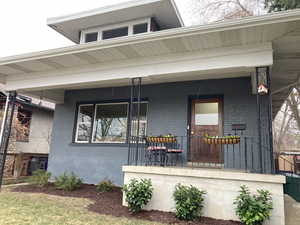 View of front facade featuring brick siding and covered porch