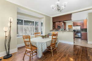 Dining area with a chandelier, baseboards, and wood finished floors