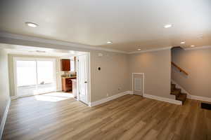 Family and dining room featuring stairs, new LVP flooring, and ornamental molding