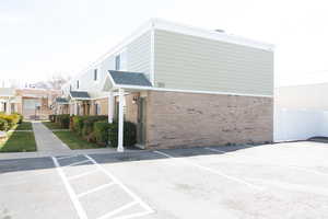 View of side of home featuring brick, siding and fence