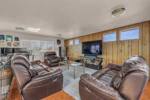 Carpeted living room featuring wood walls