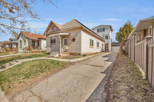 View of front of property featuring brick siding, a shingled roof, a front lawn, and fence