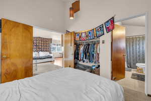 Bedroom featuring tile patterned floors, a high ceiling, a closet, and connected bathroom