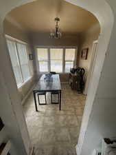 Dining space featuring a chandelier, arched walkways, and baseboards