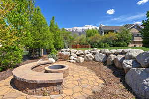 View of patio with a fire pit, fence, and a mountain view