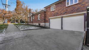 View of home's exterior with brick siding, an attached garage, and driveway