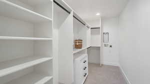 Walk in closet with light carpet